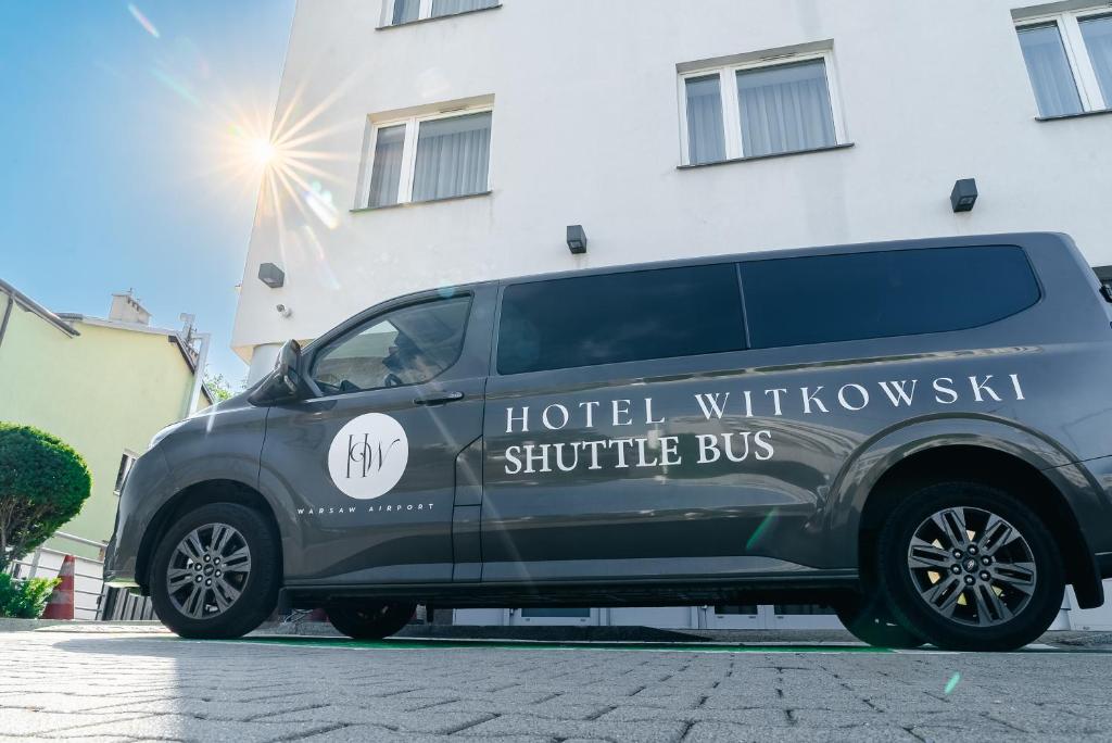 a black van parked in front of a building at Hotel Witkowski Warsaw Airport in Warsaw