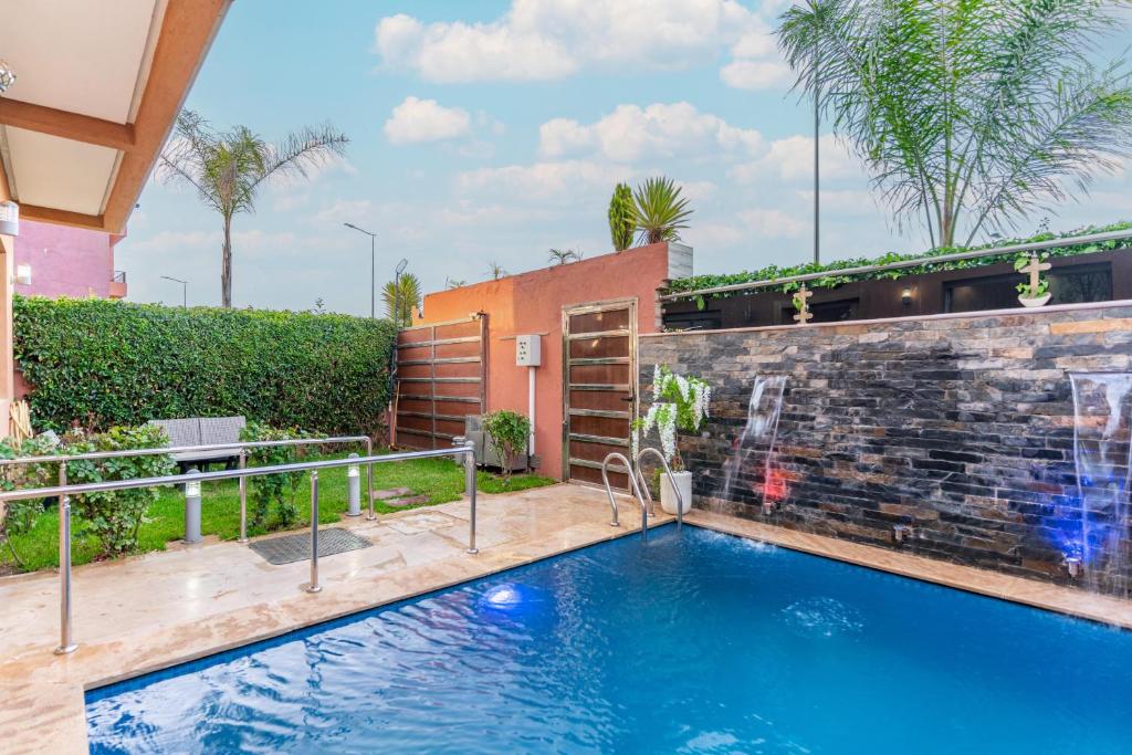 a swimming pool in the backyard of a house with a brick wall at Petit-villa avec piscine in Marrakesh