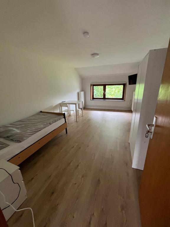 a room with a bed and a table and a window at Einzelzimmer in Jerrishoe