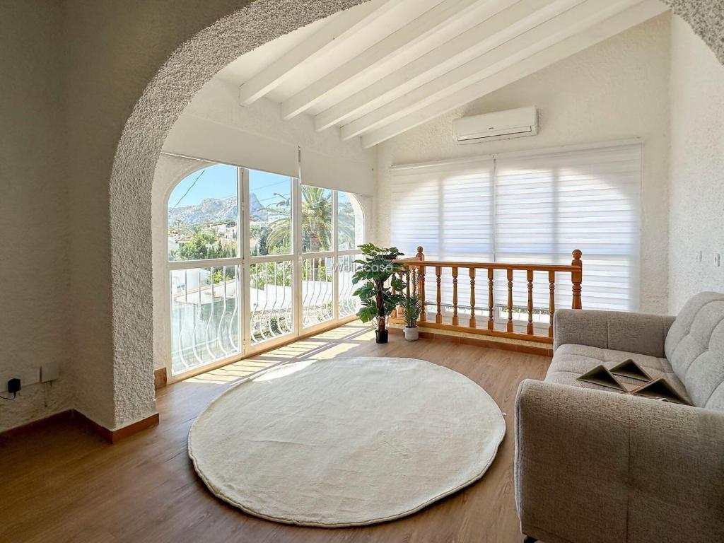 a living room with a couch and a large window at Villa Peñón View in Calpe
