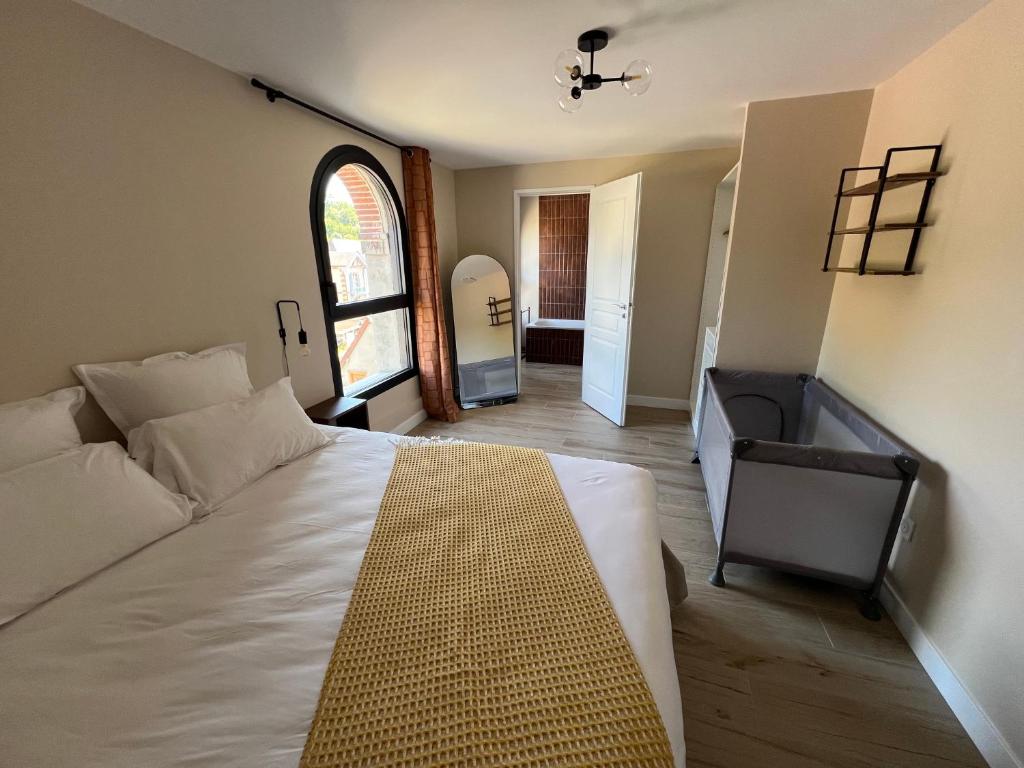 a bedroom with a large white bed and a window at Suite Rivière in Lèves