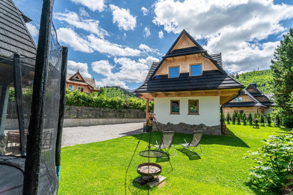 a house with a swing in the yard at Kirowy Domek I in Kościelisko