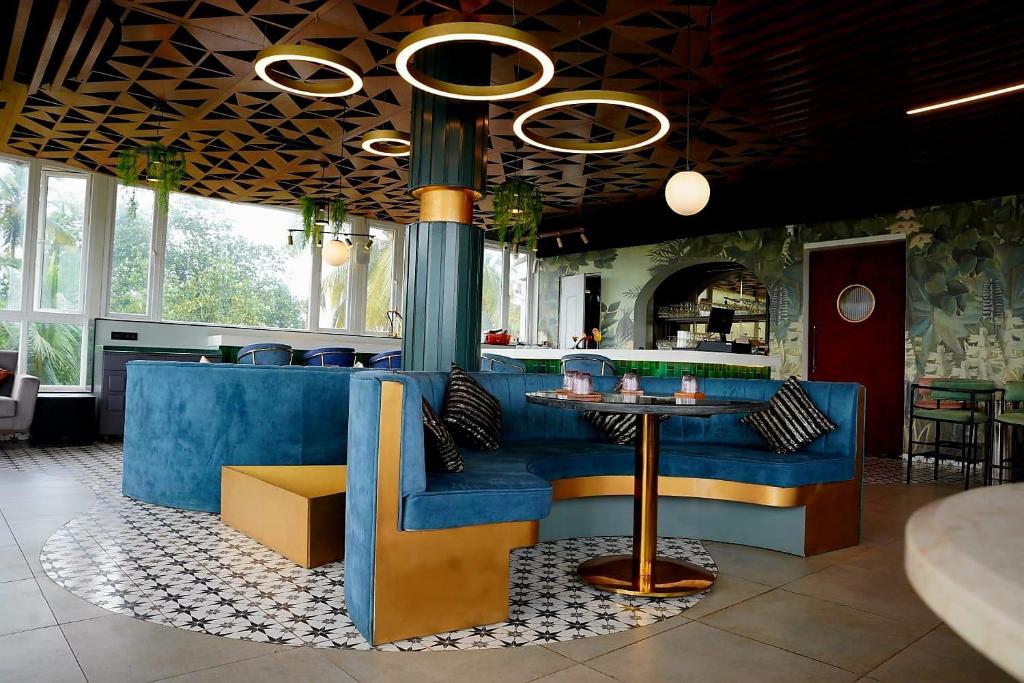 a restaurant with a blue couch and a bar at SOLARAA iNN in Anjuna
