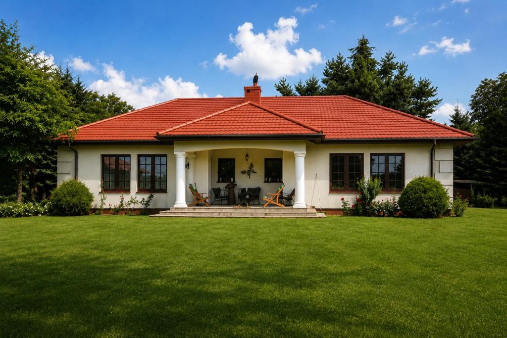 a small white house with a red roof at Siedlisko Studzianki in Studzianki Pancerne