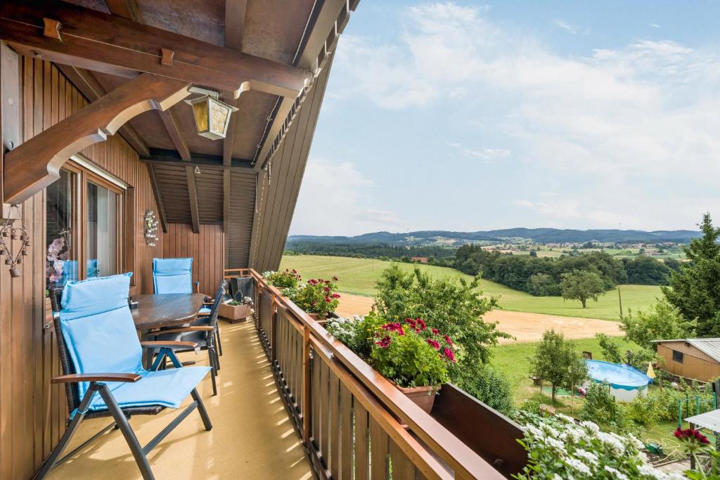 a balcony with blue chairs and a table on a house at Ferienwohnung Panorama in Freiamt