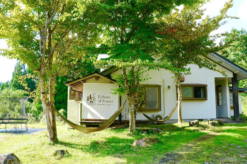 a house with a hammock in front of it at Echoes of Forest エコーズオブフォレスト 森の音が聴こえるロッジ in Minamioguni
