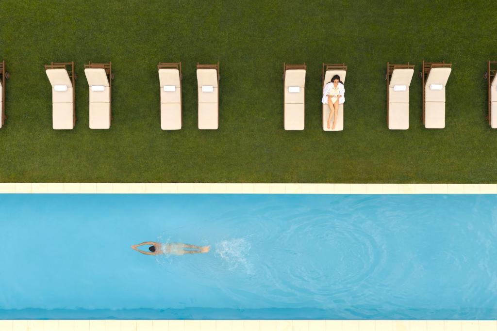 a row of chairs next to a swimming pool at COMO Cordeillan-Bages in Pauillac
