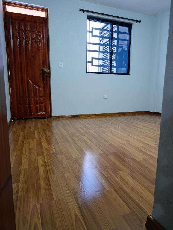 an empty room with a door and a wooden floor at Huset södra Quito in Quito