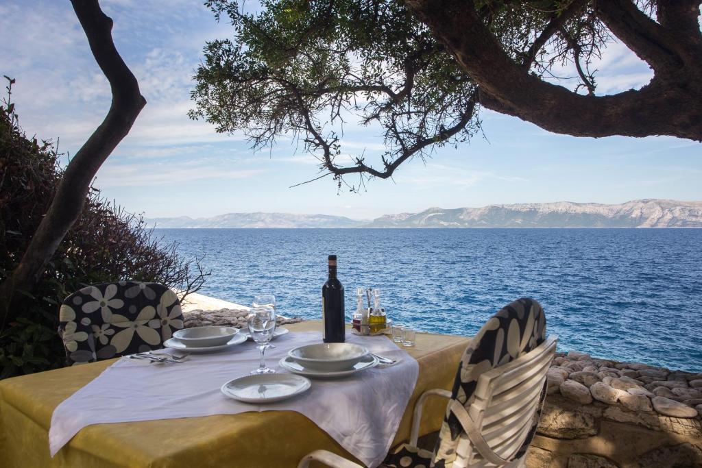 Guest House Hazdovac في Kozarica: طاولة مع زجاجة من النبيذ على المحيط