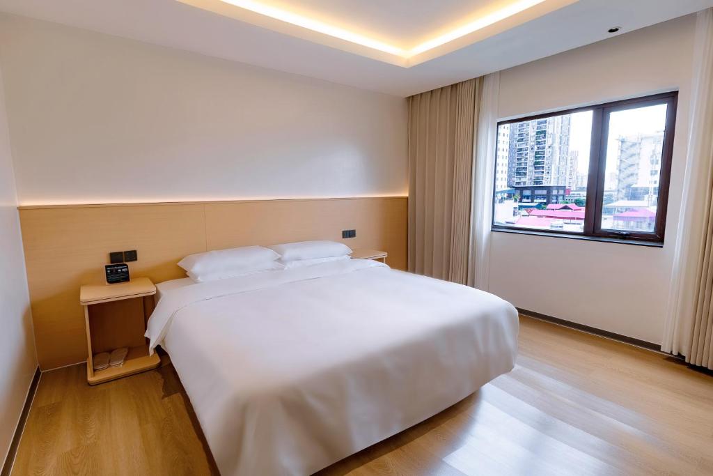 a bedroom with a large white bed and a window at Hera Hotel in Hanoi