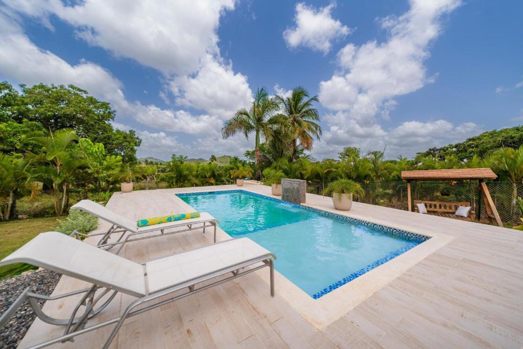 a swimming pool with a chair and avisorvisor at Villa Campestre by Otium in Higuey