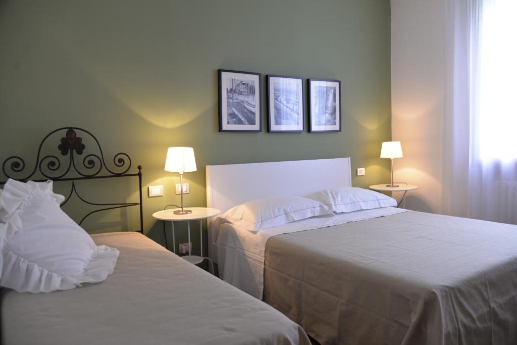 a bedroom with two beds and two tables with lamps at Bed And Breakfast 22 Garibaldi Home in Riccione