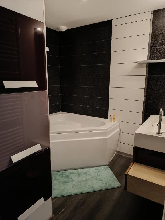 a bathroom with a white tub and a sink at Petite pom in Azay-le-Rideau