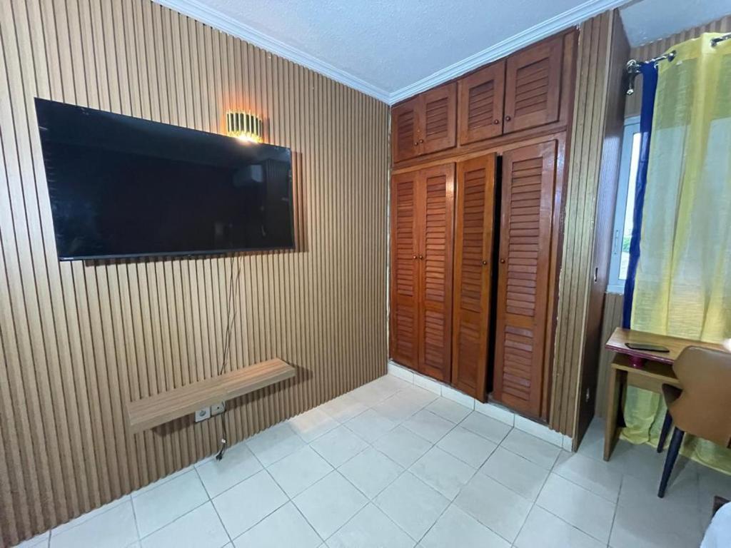 a room with a flat screen tv on a wall at Lux meublé in Douala
