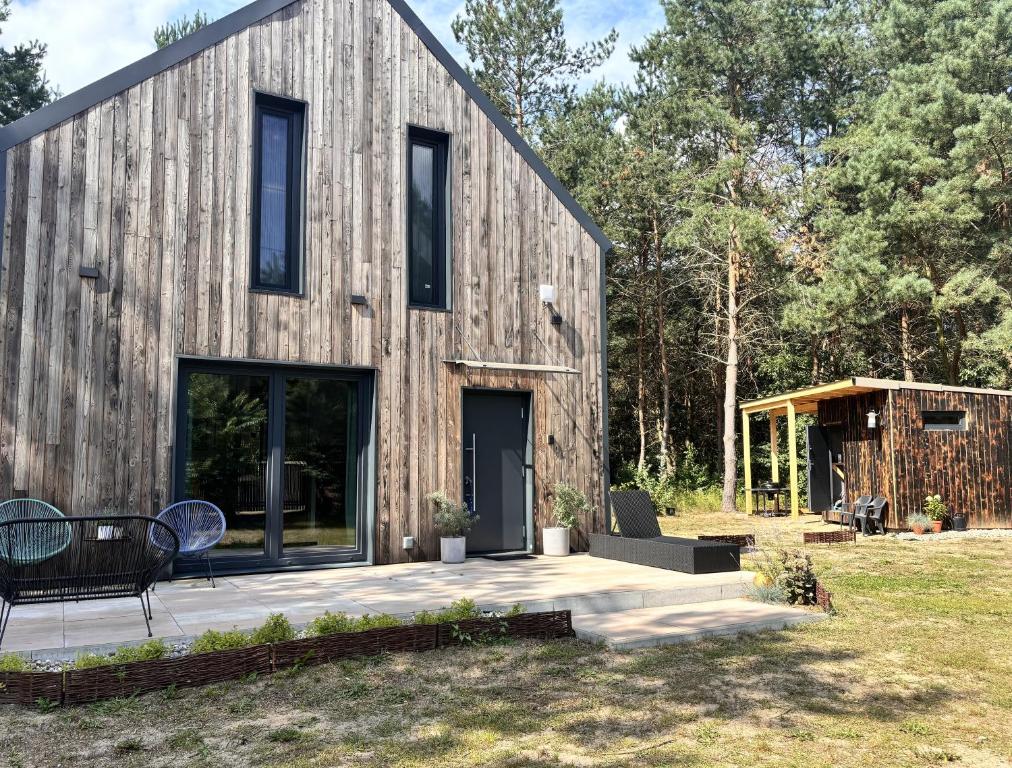 a barn style house with a wooden facade at Forest Cabin Modern Barn and Private Woods in Jamielnik