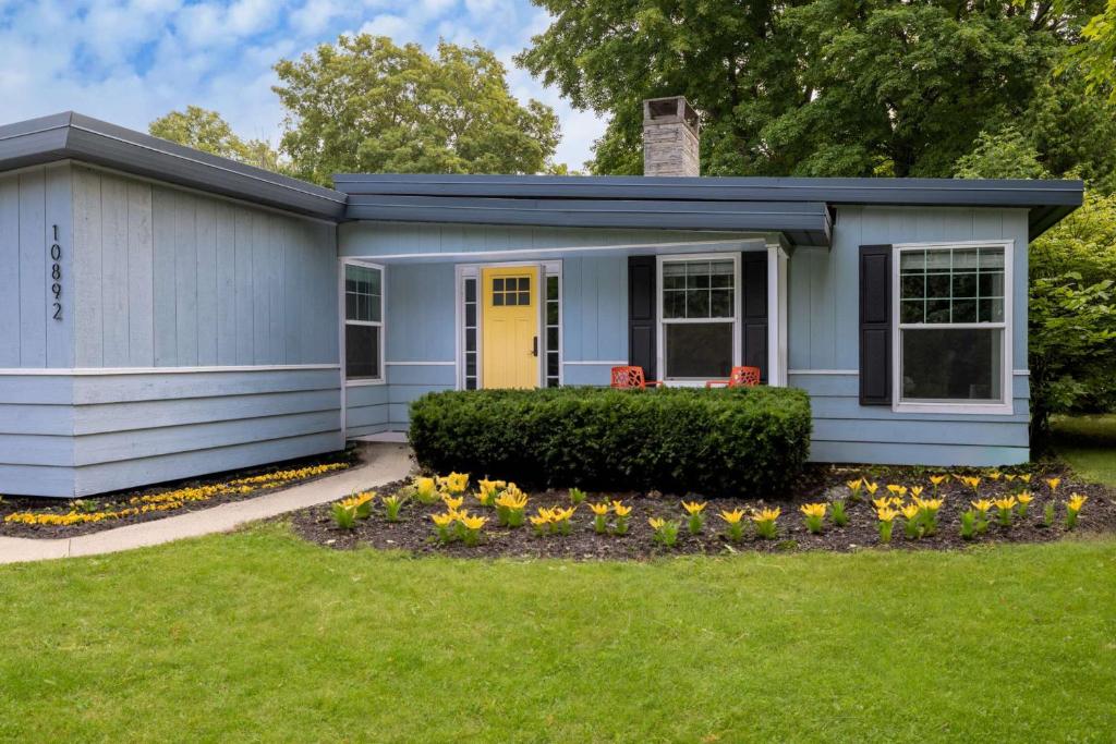 a tiny house with a yellow door in a yard at High Garden by Simple Life Rentals in Sister Bay