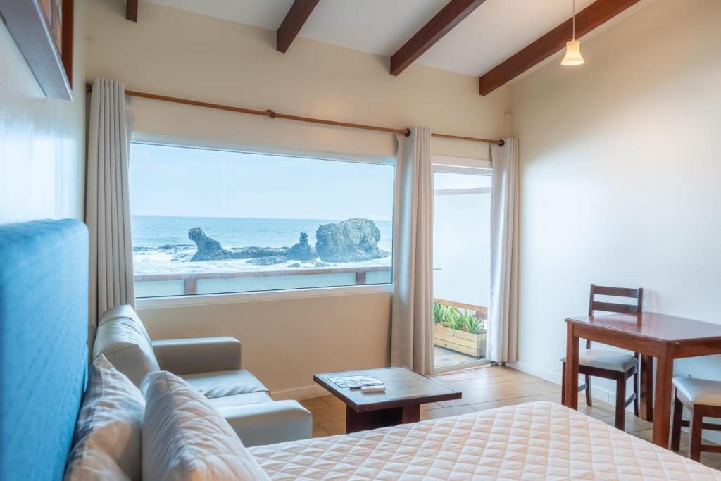 a bedroom with a bed and a view of the ocean at Hotel Roca Sunzal in La Libertad