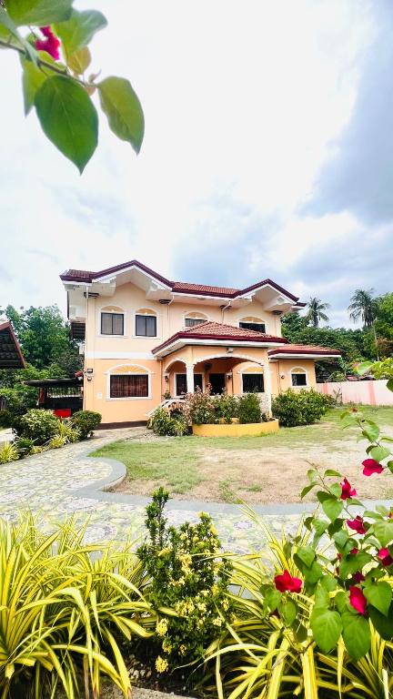 a large house with a garden in front of it at Chateau La Princesa with cozy garden & bar in Puerto Princesa City