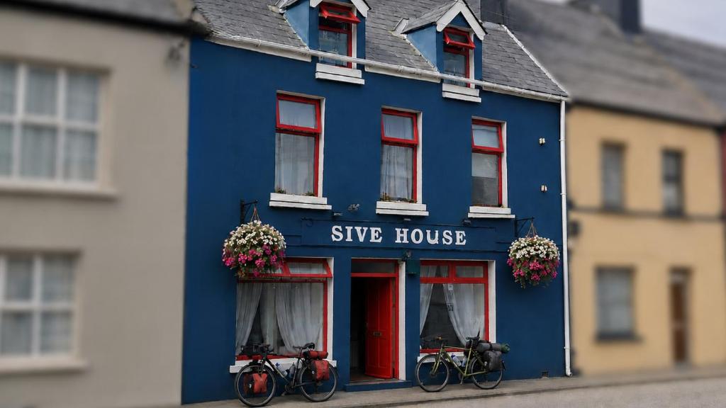 a blue building with two bikes parked outside of it at Sive Budget Accommodation in Cahersiveen