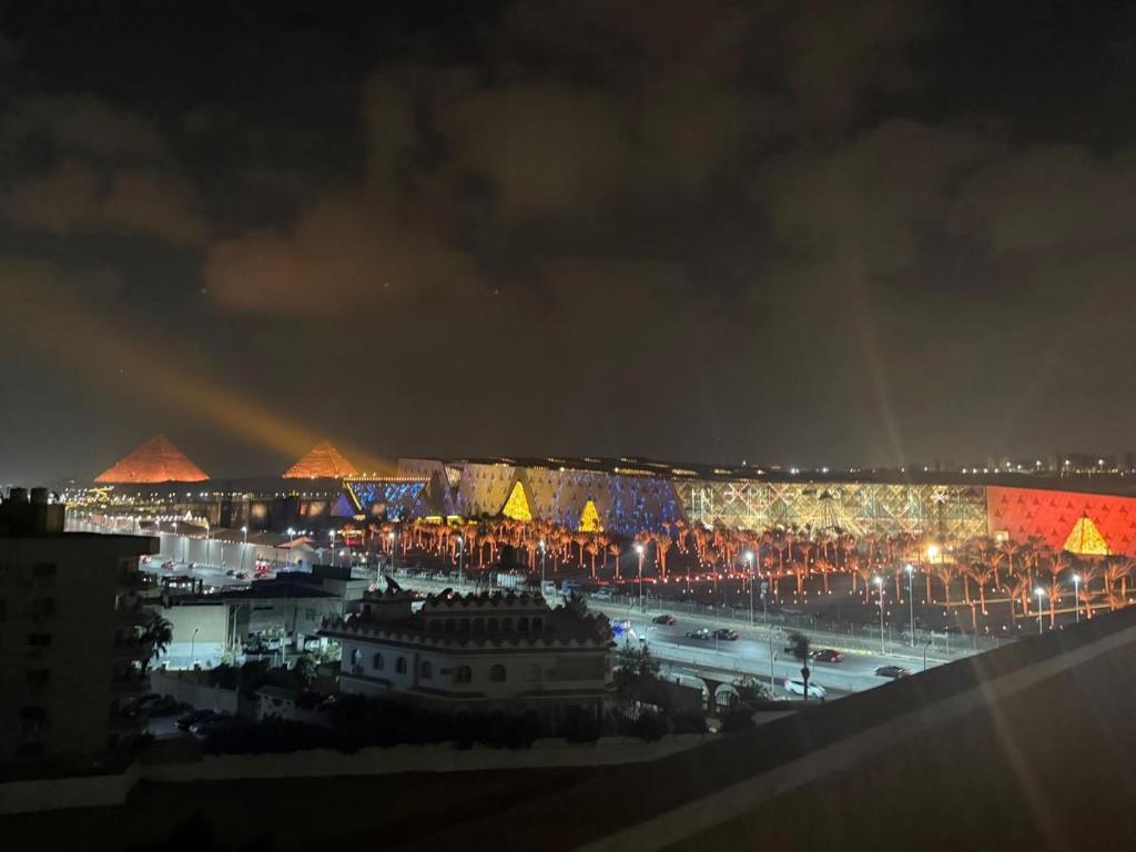 a view of a city at night with pyramids at Gem View Grand Boutique in Cairo