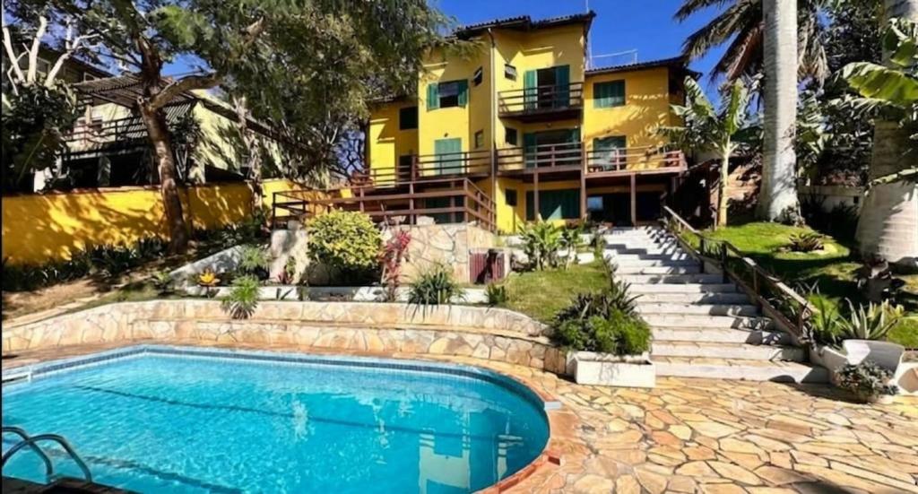 a house with a swimming pool in front of a building at Pousada Oceanica Buzios in Búzios