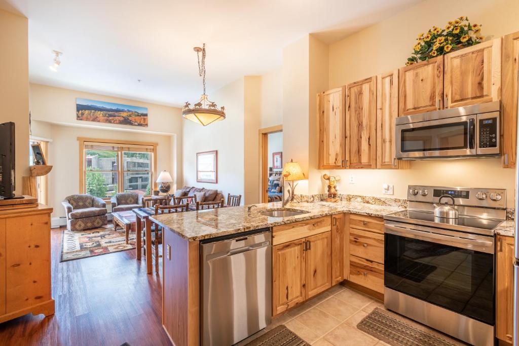 a kitchen with wooden cabinets and stainless steel appliances at Copper Springs Lodge 433 in Copper Mountain