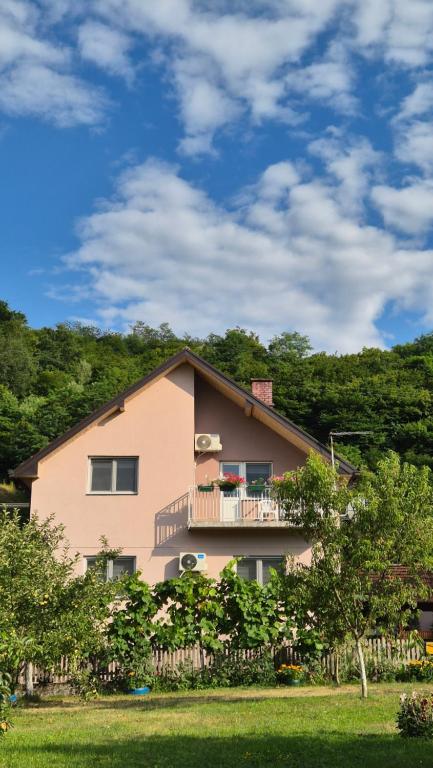 una casa rosa con un balcone in cima di STD Gavrilović a Bajina Bašta