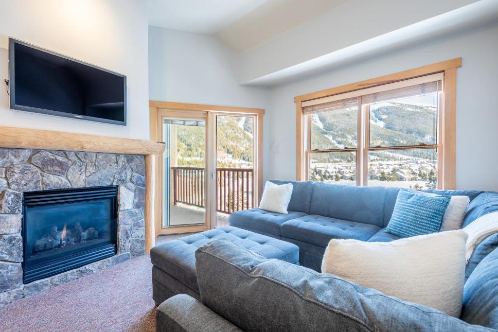 a living room with a blue couch and a fireplace at Copper Springs Lodge 404 in Copper Mountain