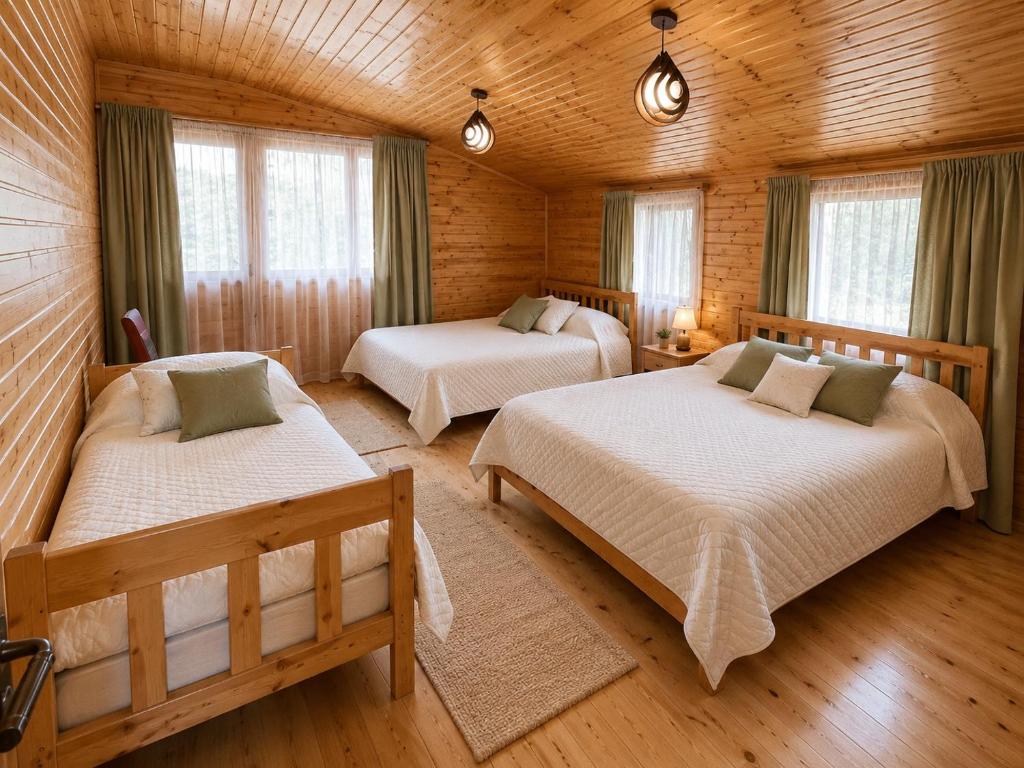 a bedroom with two beds in a log cabin at Ioane's Chalet in Mestia