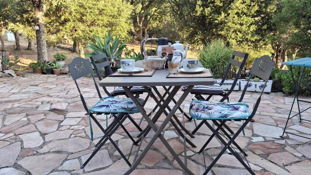 a table and chairs with a tea set on it at Maison Cistaredda in Sotta