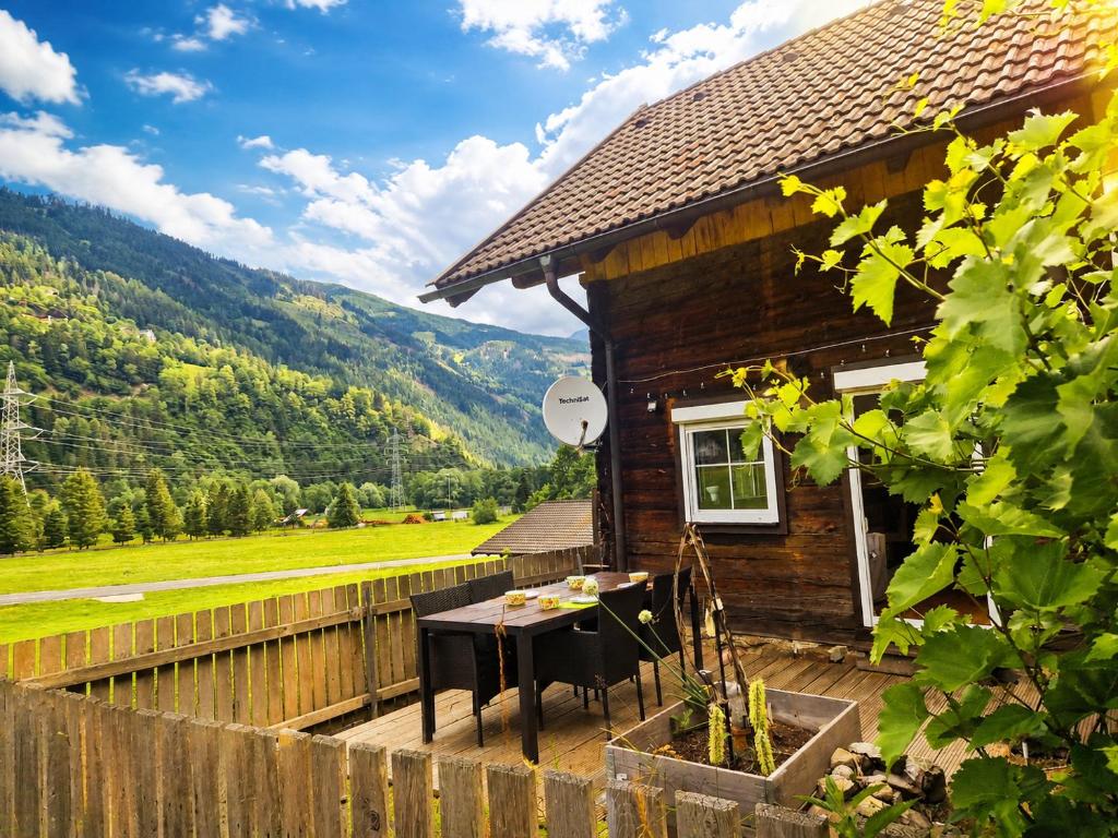 a wooden house with a table on the deck at Ferienhaus mit Bergblick am Wald in Stall