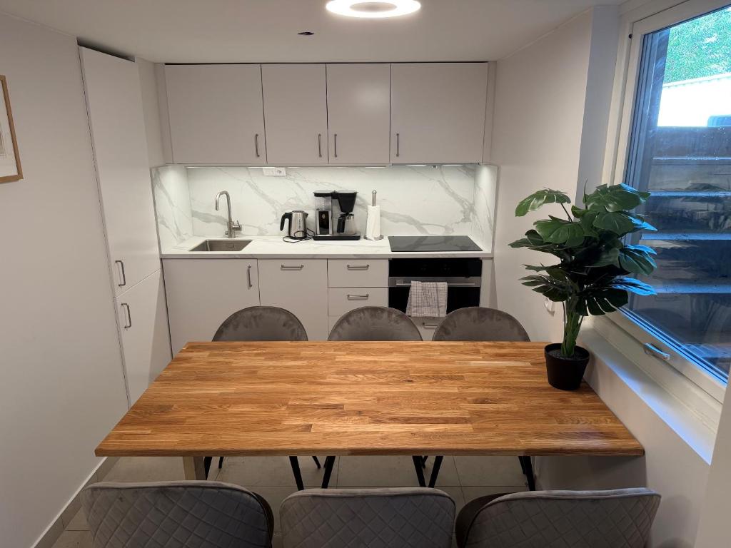 a kitchen with a wooden table and chairs and a sink at Lägenhet 36B in Båstad
