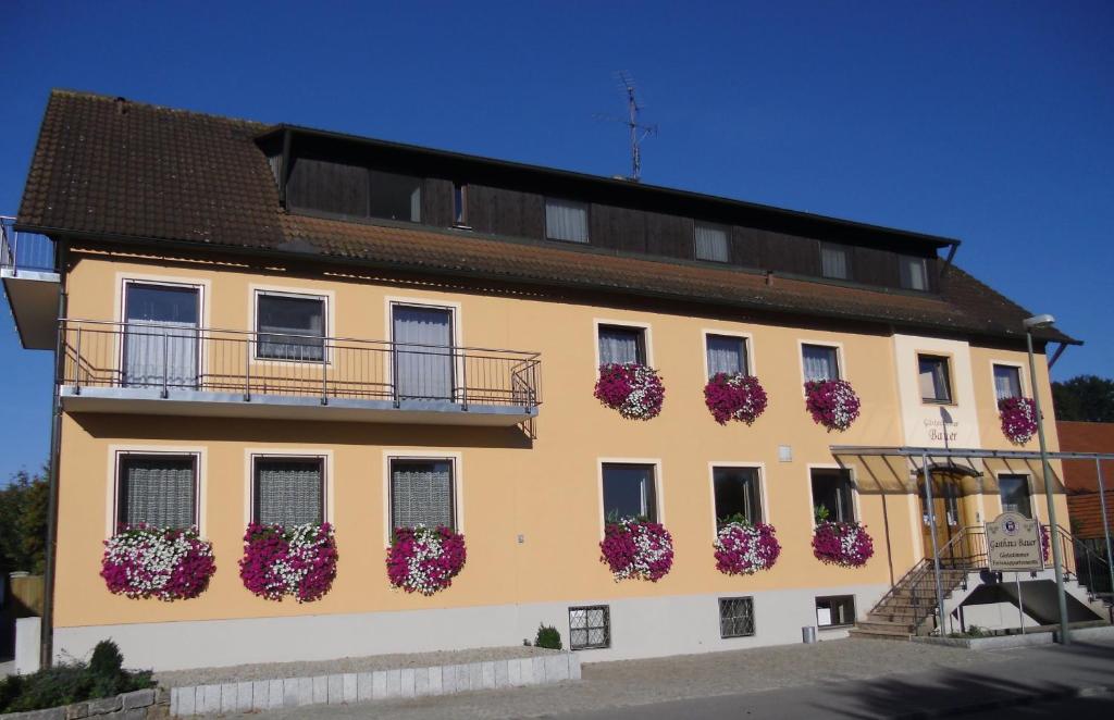ein Gebäude mit Blumentopfen auf der Seite in der Unterkunft Pension Elsendorf in Elsendorf