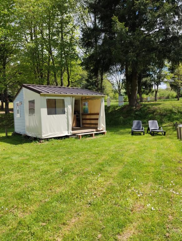 a small tent in a field with two chairs at TIthome in Cunlhat