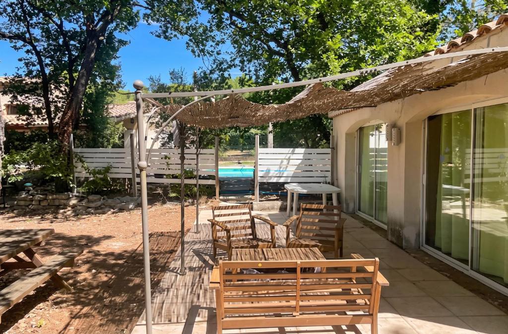 a patio with benches and a table and a pool at Maison confortable à Velleron de 50 m² avec piscine in Velleron