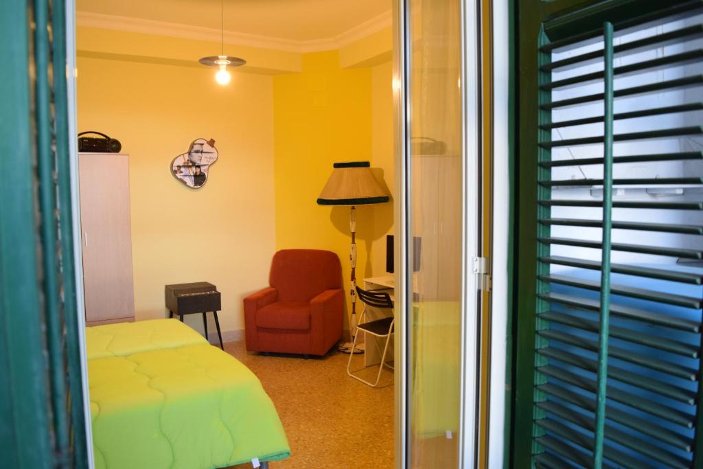 ein Schlafzimmer mit einem Bett, einem Stuhl und einem Schreibtisch in der Unterkunft L'Aquilone B&B in Palermo