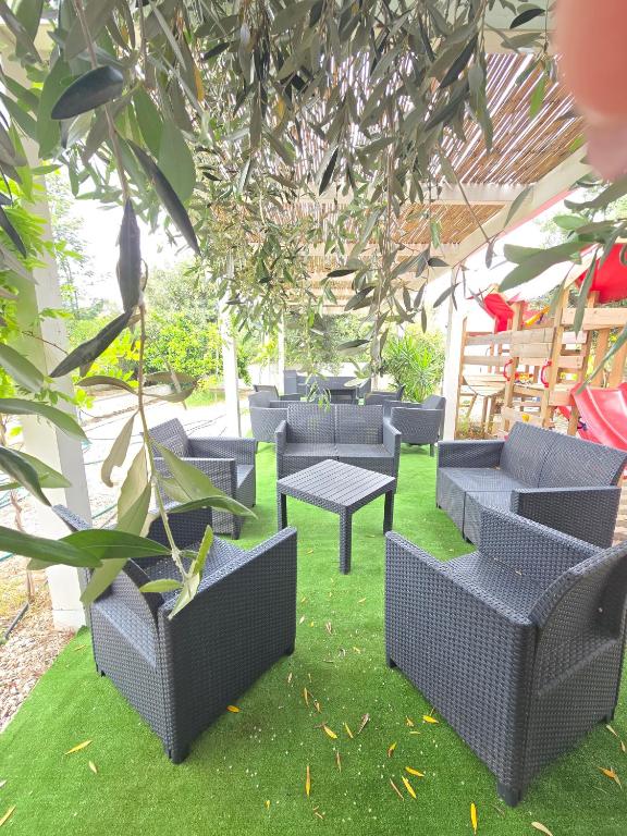 a group of wicker chairs and tables on the grass at Affittacamere Vacanze a Posada in San Giovanni
