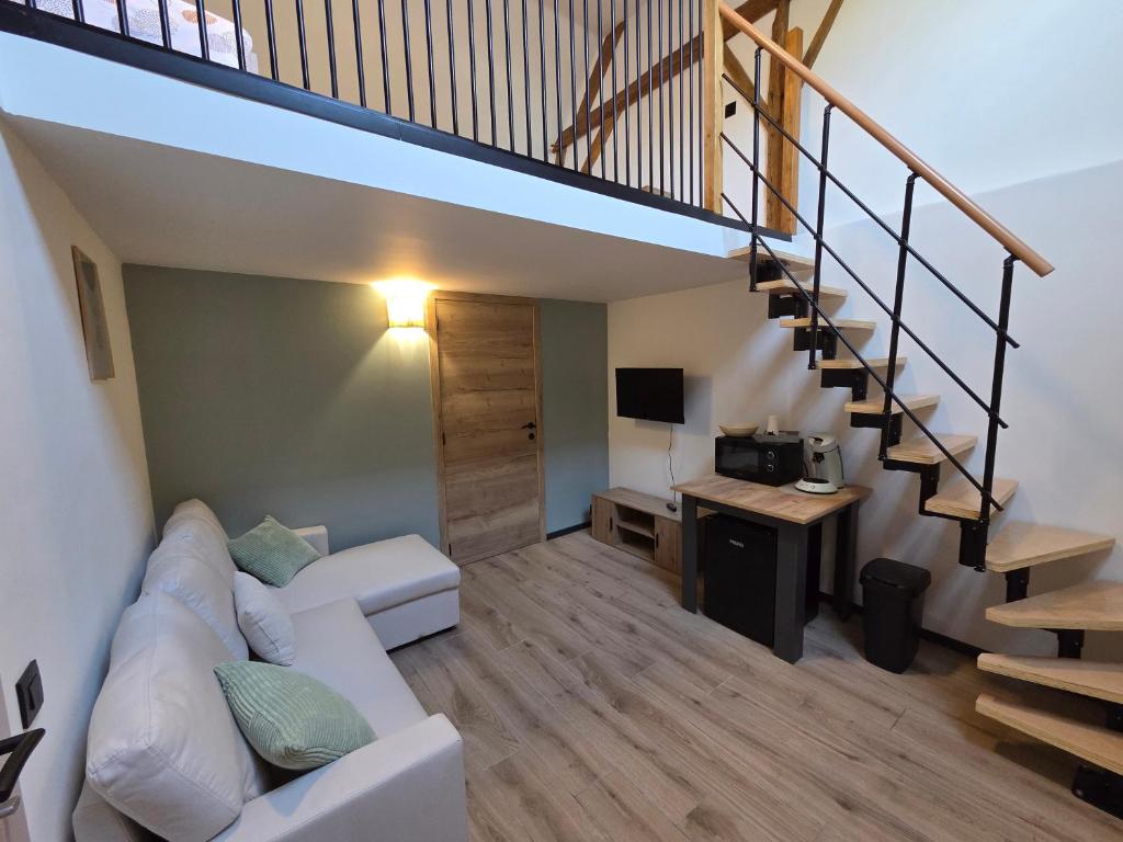 a living room with a white couch and a staircase at L oasis de Détente - le Cocon - gîte 4 personnes avec 1h d accès à la piscine privée et terrasse aménagée par nuit réservée - climatisation - à 2km de Pairi Daiza in Brugelette