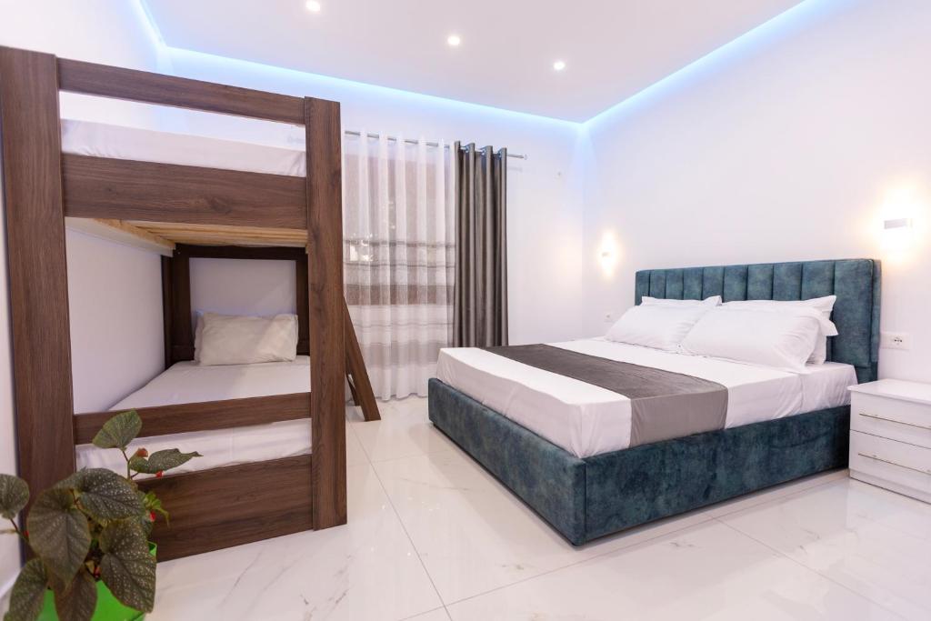 a bedroom with two beds and a bunk bed at Sunrise Hotel Vila in Vlorë