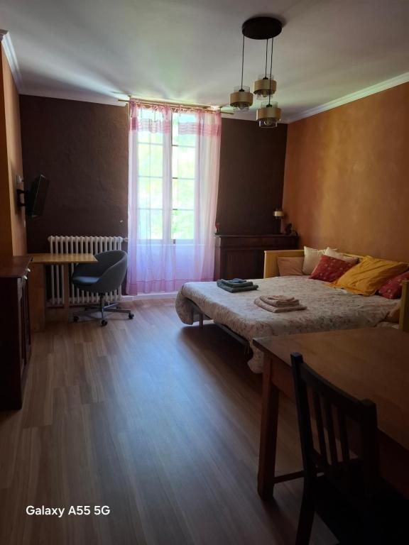 a bedroom with a bed and a desk and a table at Ty Méluzhine in Huelgoat