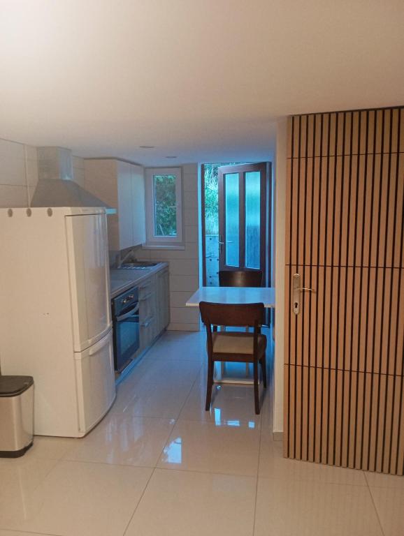 a kitchen with a refrigerator and a table and a chair at apartmandomazlice in Domažlice