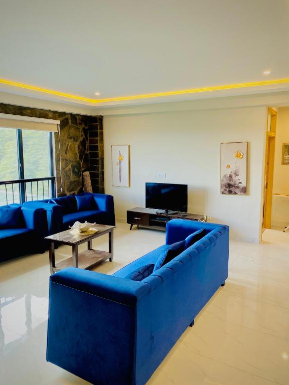 a living room with blue couches and a tv at Snowra heights in Abbottabad