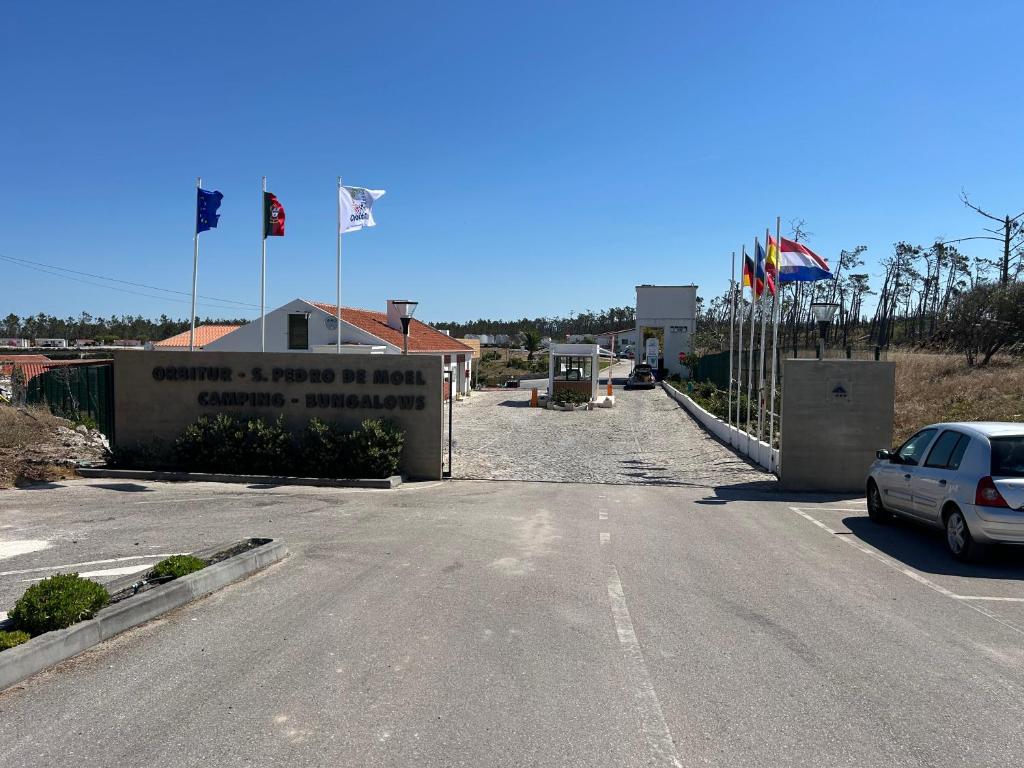 a car parked on the side of a road with flags at Parque De Campismo Orbitur Sao Pedro De Moel in São Pedro de Moel