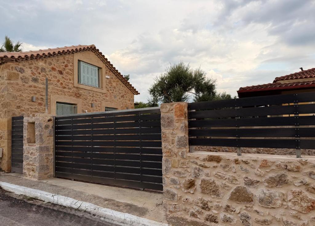 a black fence in front of a house at The Stone Loft in Arfará
