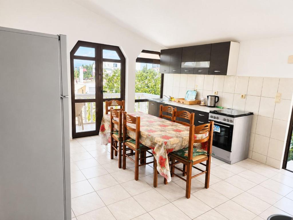 a kitchen with a table and chairs and a stove at Esko Rooms in Donji Štoj