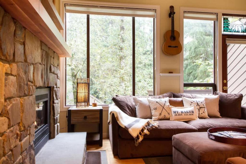 a living room with a couch and a fireplace at Rivers Edge at Snowater in Glacier