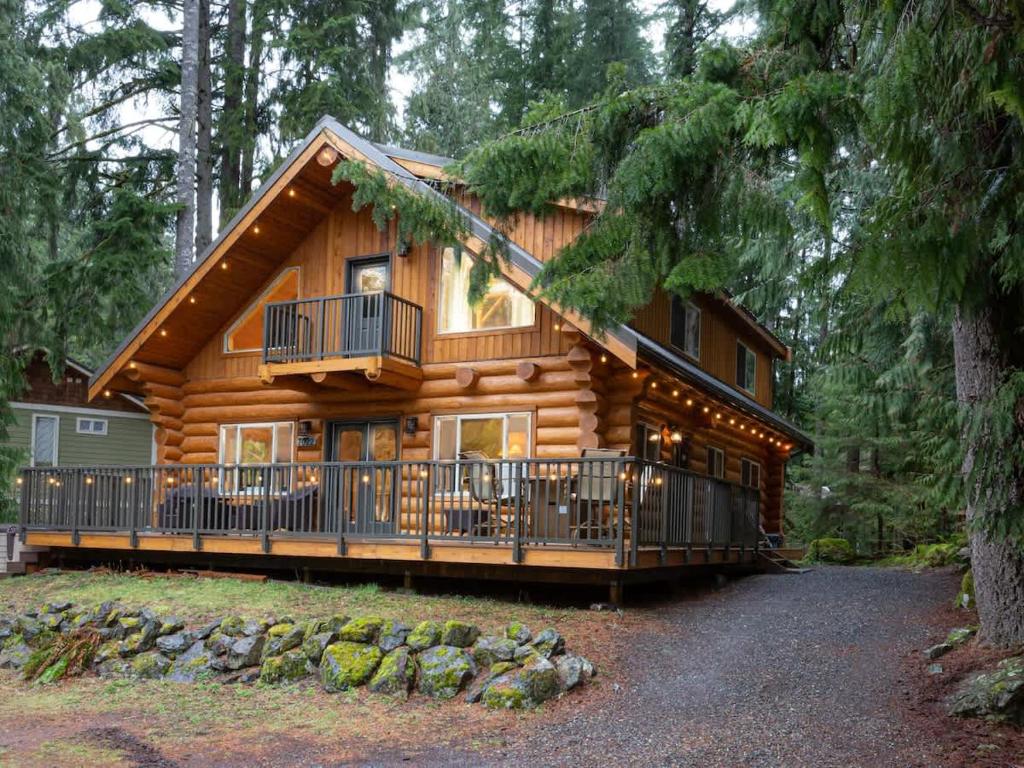 a log cabin in the woods with a balcony at Stargazer Chalet in Glacier