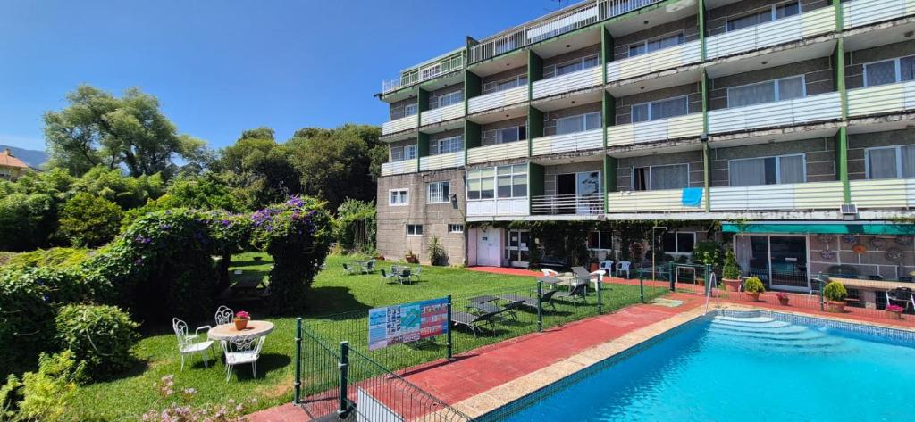 a building with a swimming pool in front of a building at Las Islas in Vilaboa