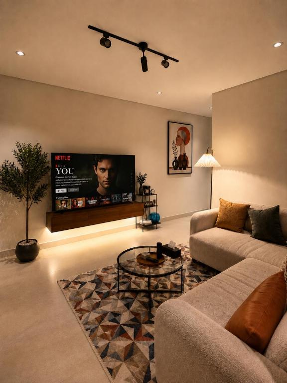 a living room with a couch and a flat screen tv at سويت إبرام- بتصميم فاخر بدخول ذاتي in Dammam
