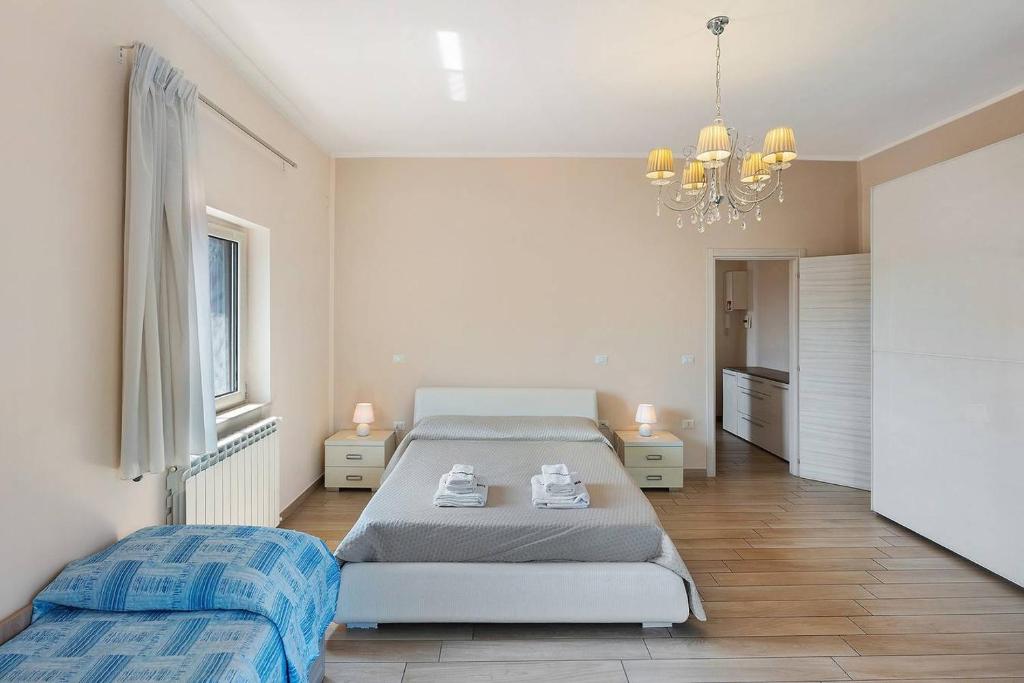 a bedroom with two beds and a chandelier at DIEGOPAS Sweet Home in SantʼAntonio Abate